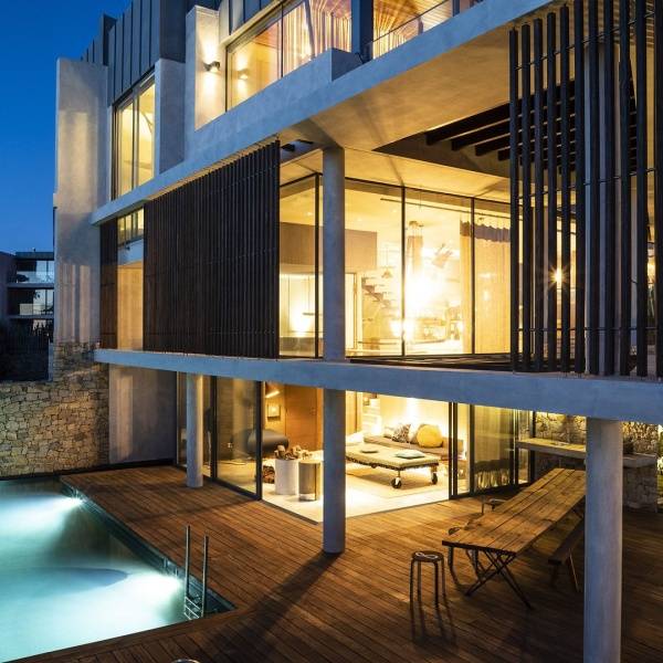 Luxurious room at Areias do Seixo Hotel with a stunning view of the dunes and sea, featuring elegant decor, a fireplace, and a decked terrace.